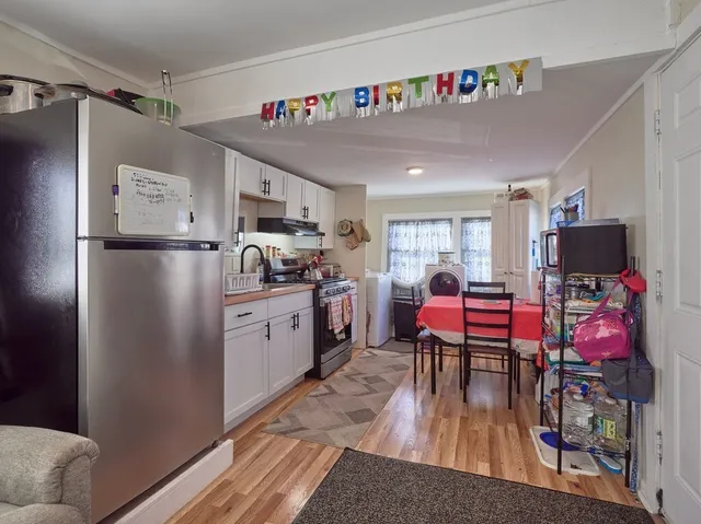 a kitchen with stainless steel appliances granite countertop a refrigerator and a dining table