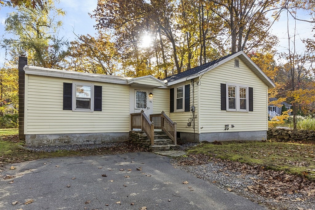 86 East Road Westminster, MA 01473 - Photo 1 of 29 a small white house with a white roof and table and chairs under an umbrella