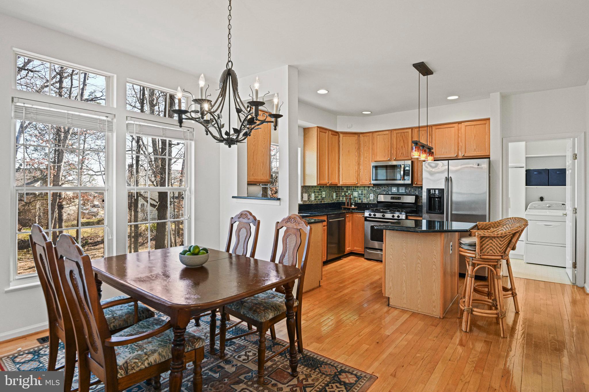 20678 Citation Drive Ashburn, VA 20147 - Photo 9 of 22 a view of a dining room with furniture a chandelier and wooden floor