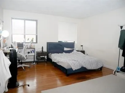 a bedroom with a bed and wooden floor