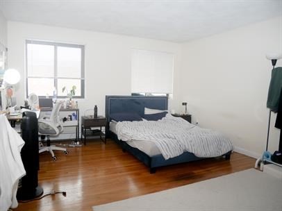 a bedroom with a bed and wooden floor