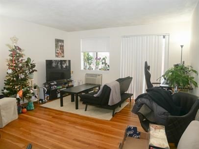 1027 Commonwealth Avenue, Unit 22 Boston, MA 02215 - Photo 3 of 4 a living room with furniture a flat screen tv and a window