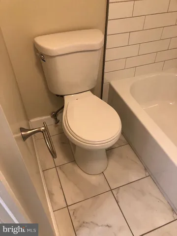 a bathroom with a toilet and a bathtub
