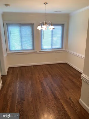 a view of a room with wooden floor and chandelier