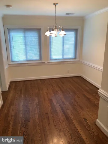 a view of a room with wooden floor and chandelier