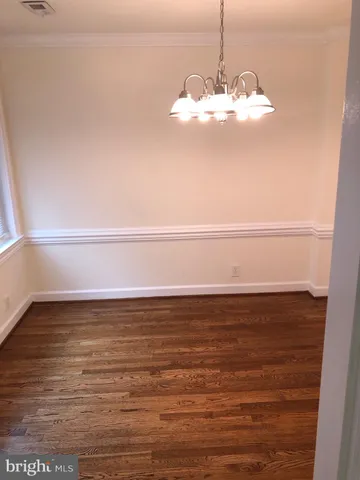 a view of a room with a ceiling fan and wooden floor