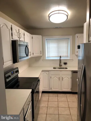 a kitchen with a sink a stove top oven and refrigerator