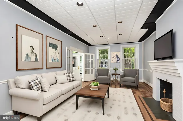 a living room with furniture a flat screen tv and a window