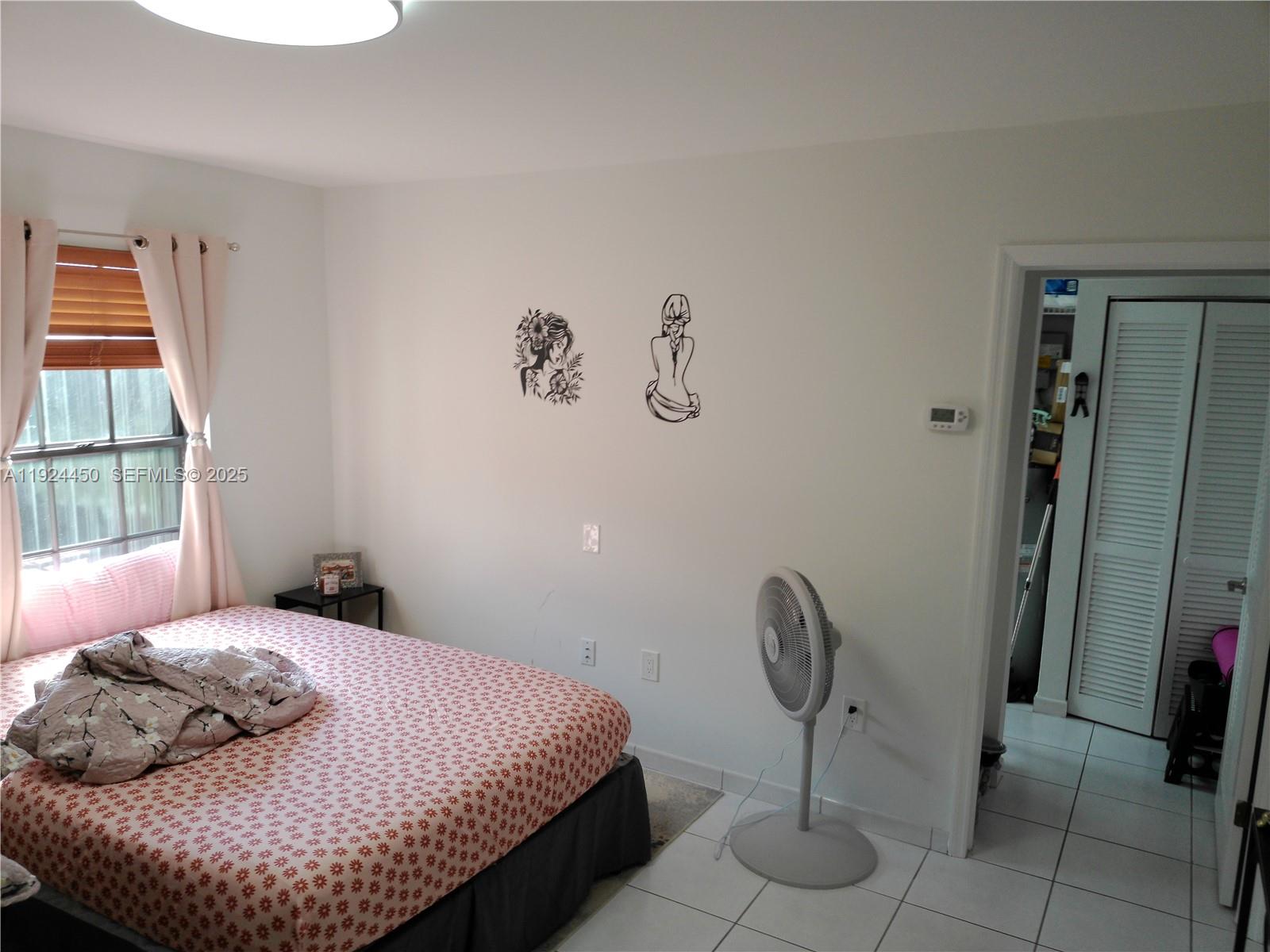 10812 Southwest 33rd Street Miami, FL 33165 - Photo 11 of 18 a bedroom with a bed and chandelier
