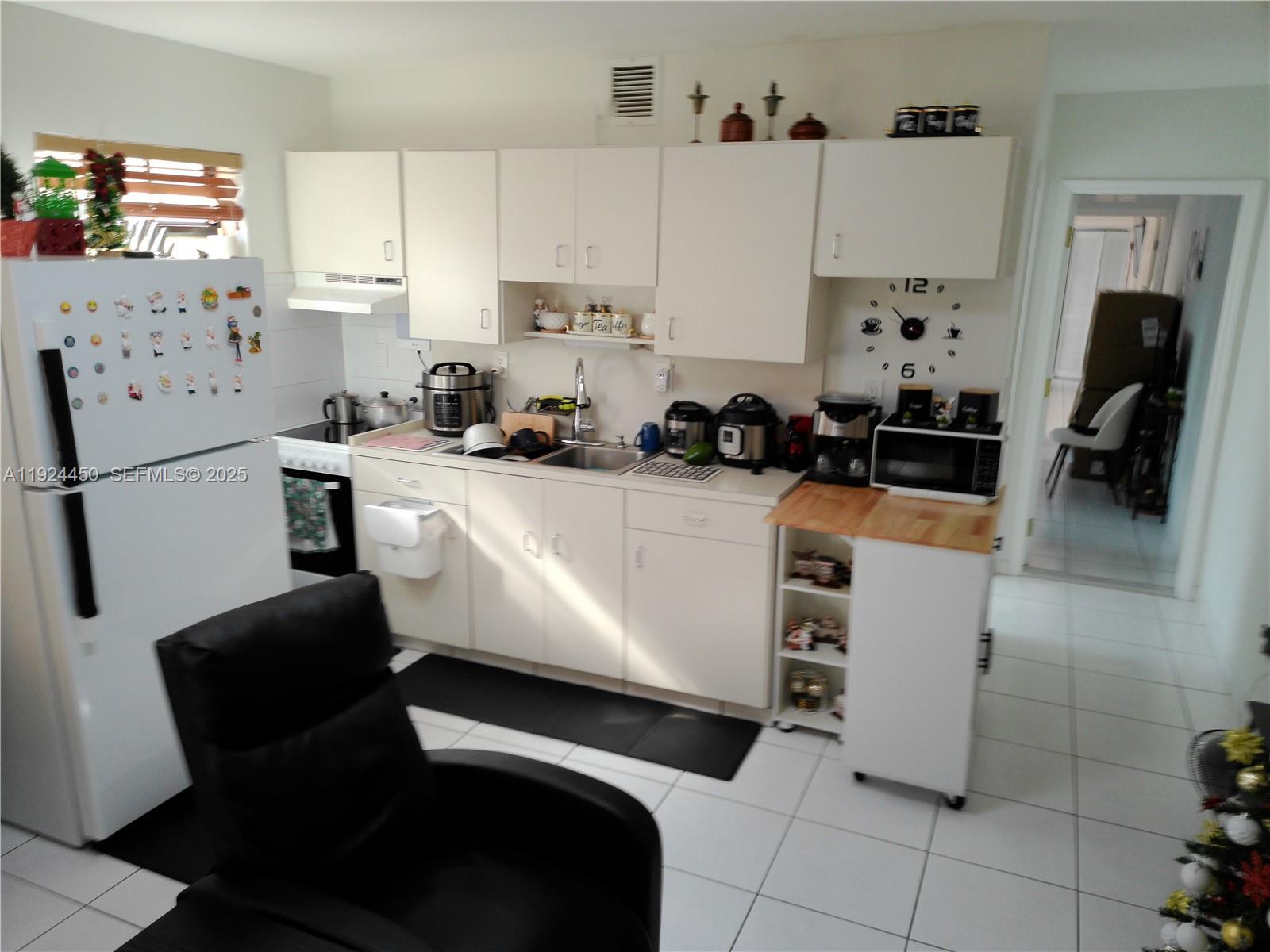 10812 Southwest 33rd Street Miami, FL 33165 - Photo 13 of 18 a kitchen with stainless steel appliances a refrigerator a sink a stove a microwave a counter top and cabinets