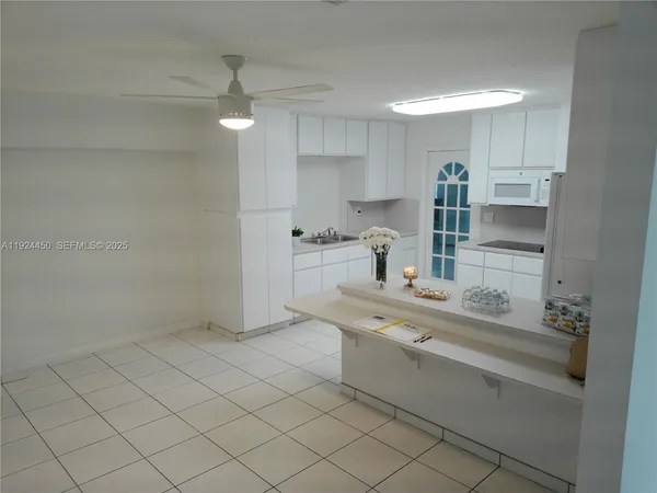 a kitchen with white cabinets and sink