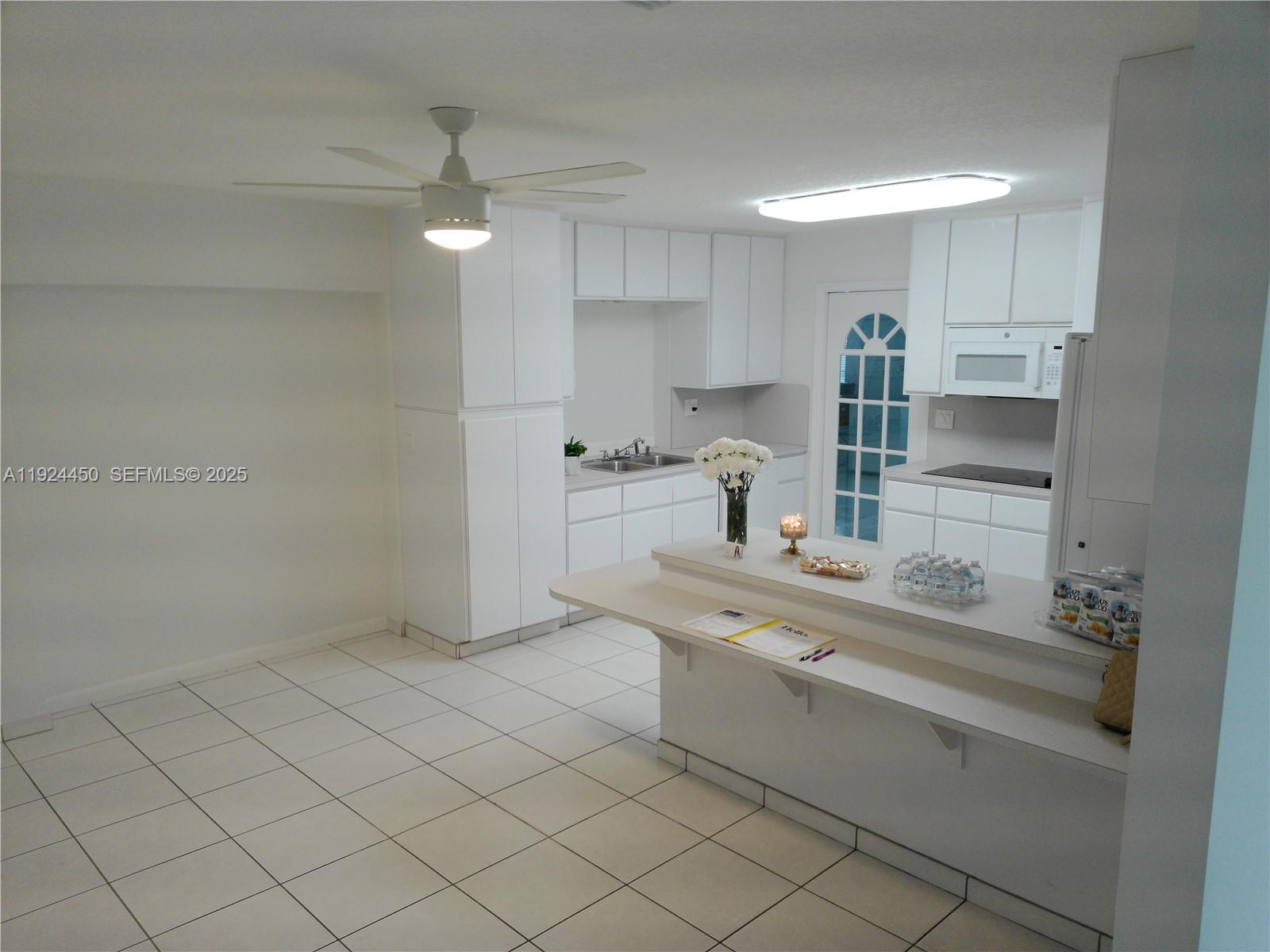 10812 Southwest 33rd Street Miami, FL 33165 - Photo 5 of 18 a kitchen with white cabinets and sink