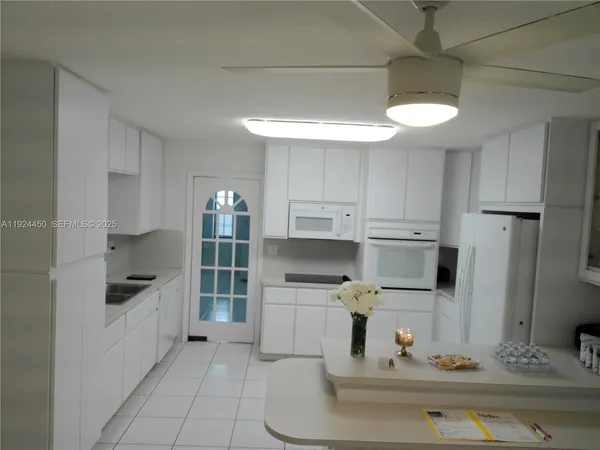 a kitchen with white cabinets and appliances