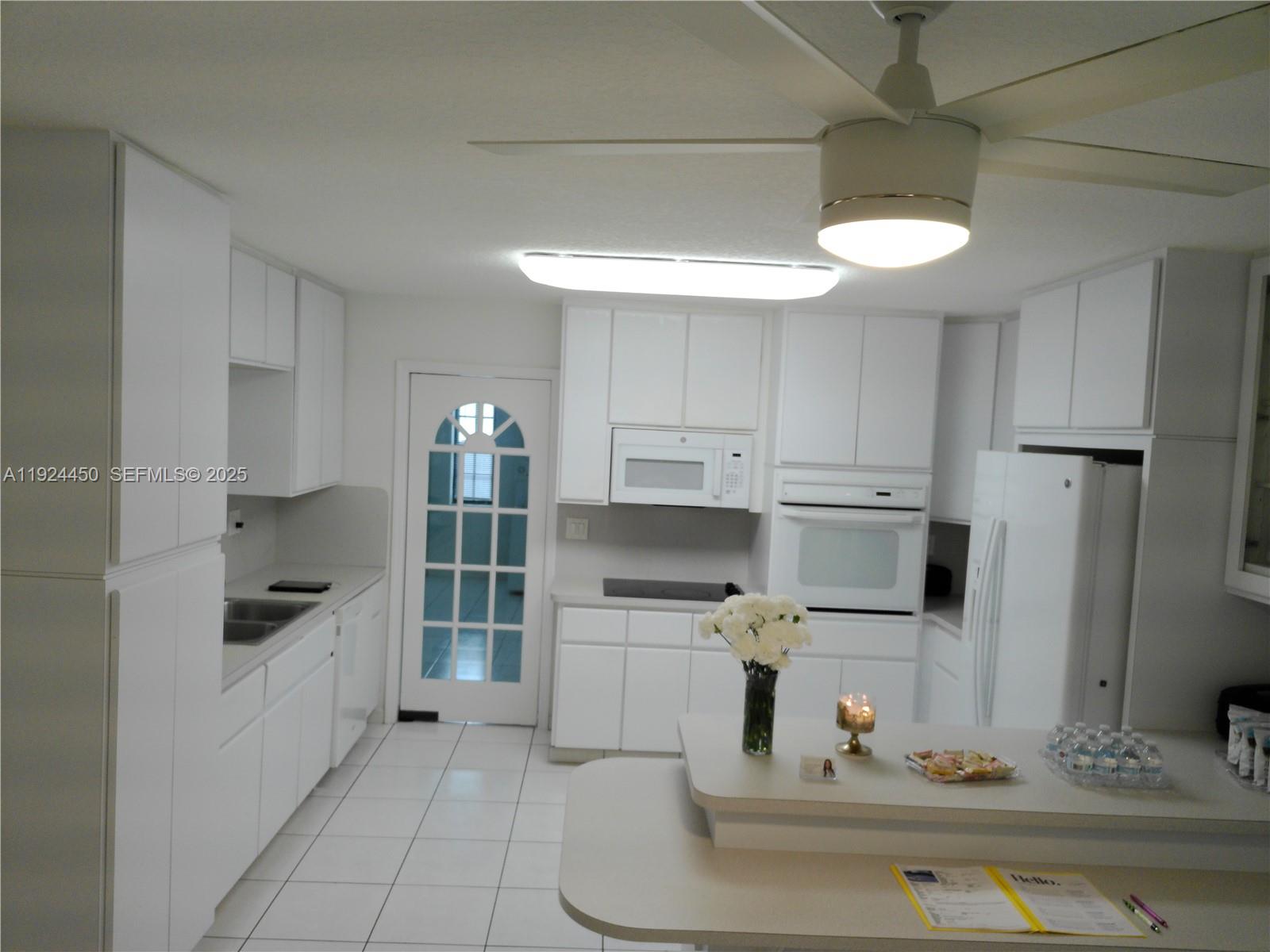 10812 Southwest 33rd Street Miami, FL 33165 - Photo 7 of 18 a kitchen with white cabinets and appliances