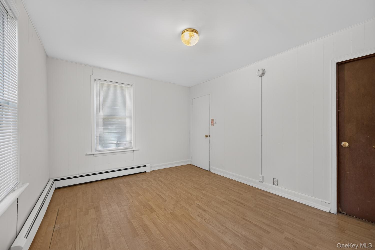 49 Cedar Street Babylon, NY 11702 - Photo 9 of 20 a view of an empty room with a window and wooden floor