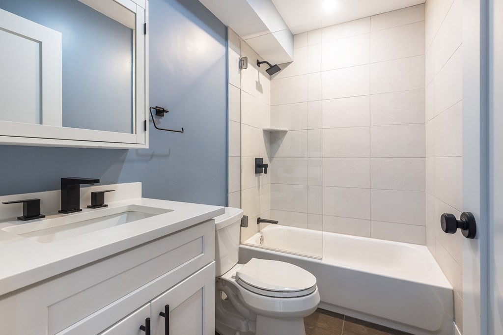 81-83 Alpine Street, Unit 2 Somerville, MA 02144 - Photo 10 of 24 a bathroom with a sink toilet vanity and shower