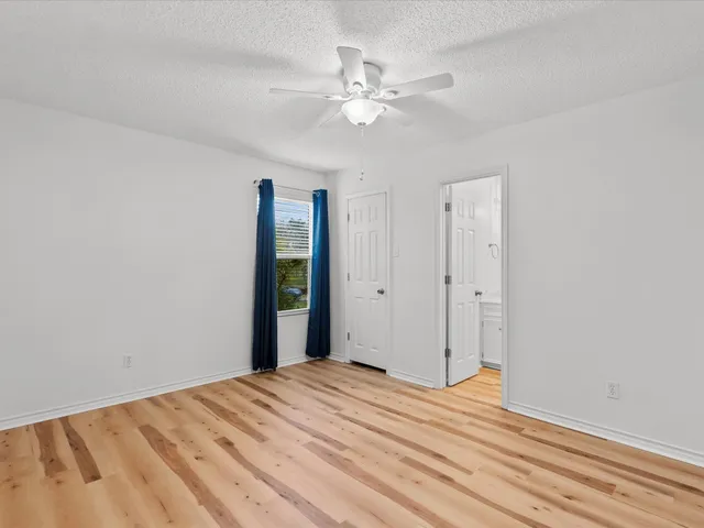 a view of a room with a bed and a chandelier fan