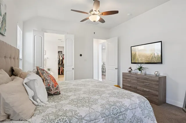 a bedroom with a bed and a flat tv screen on dresser