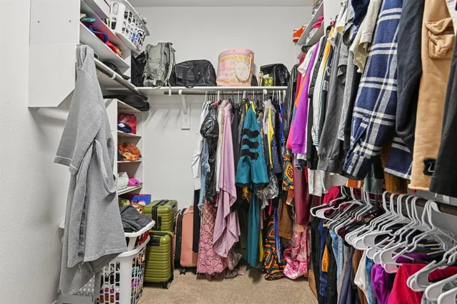 a view of walk in closet with clothes