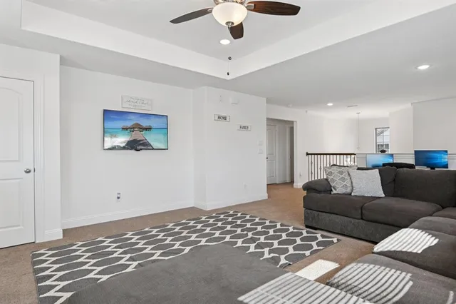 a living room with furniture and a ceiling fan