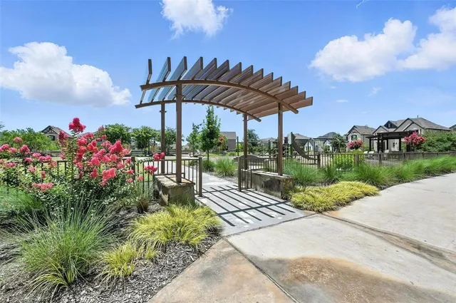 a street view with flower garden and wooden fence
