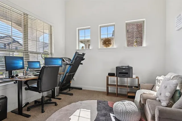 a view of a workspace with furniture and a window