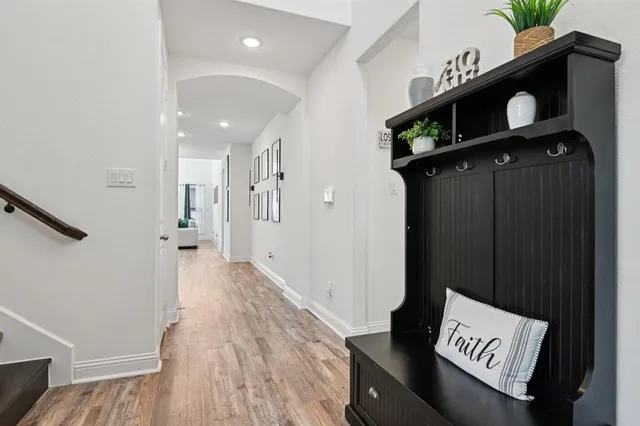 a view of a hallway with wooden floor and staircase