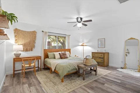 a bedroom with a bed a table and painting on the wall