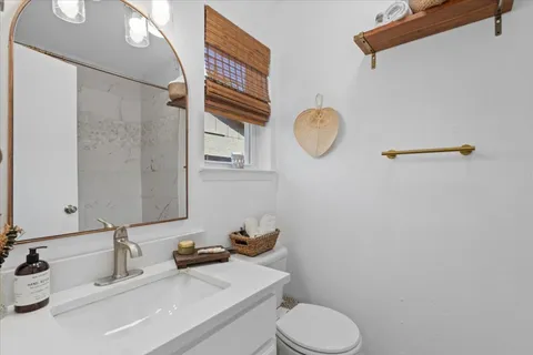 a bathroom with a sink mirror vanity and toilet