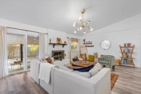 a living room with furniture a fireplace and a chandelier