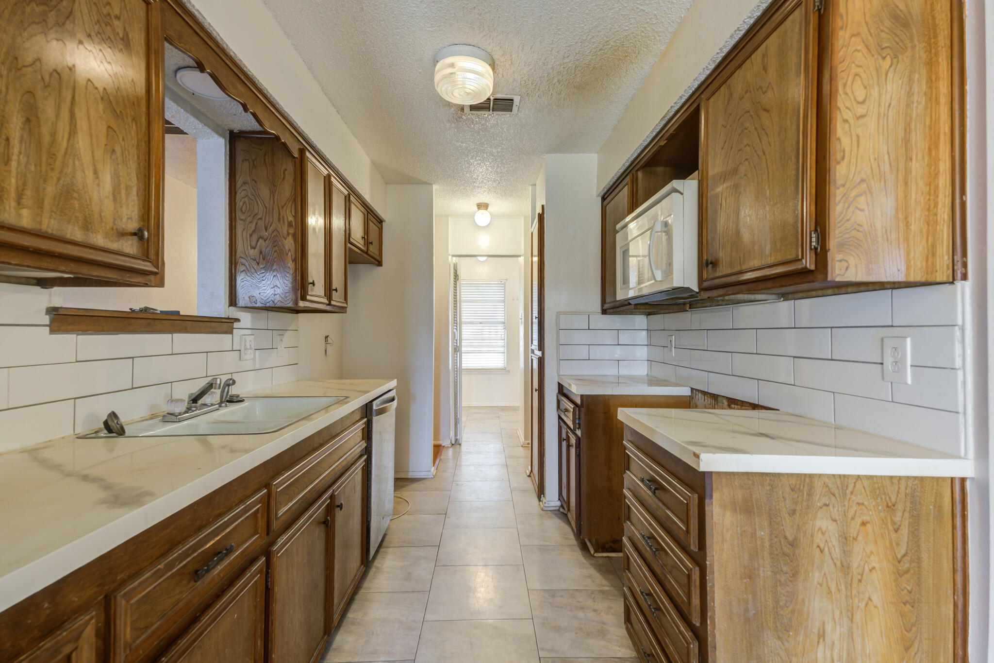 5018 70th Street Lubbock, TX 79424 - Photo 12 of 27 a kitchen with a sink stove and cabinets