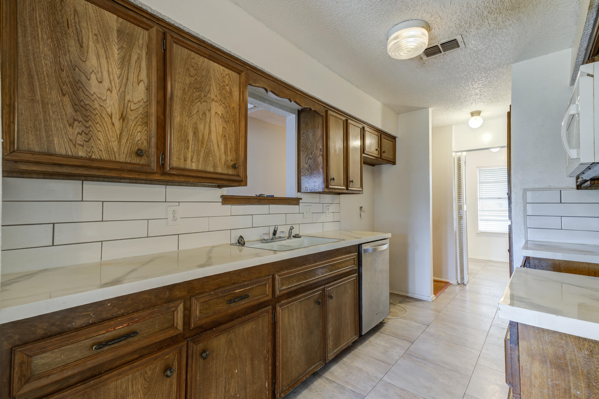 5018 70th Street Lubbock, TX 79424 - Photo 13 of 27 a kitchen with a sink and cabinets