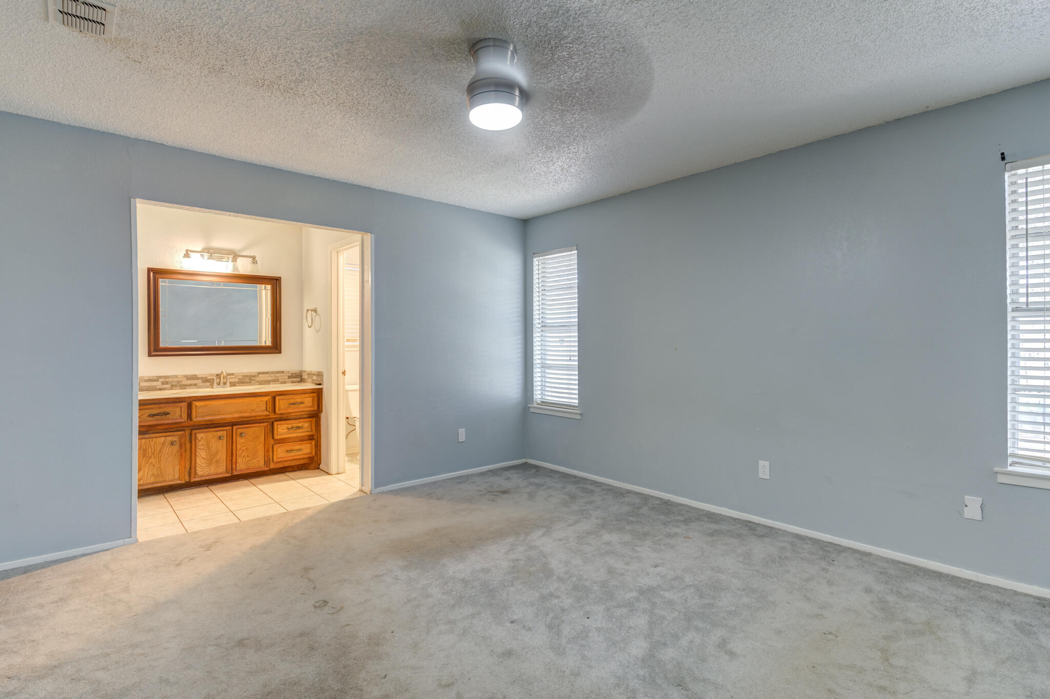 5018 70th Street Lubbock, TX 79424 - Photo 15 of 27 an empty room with a empty space and windows