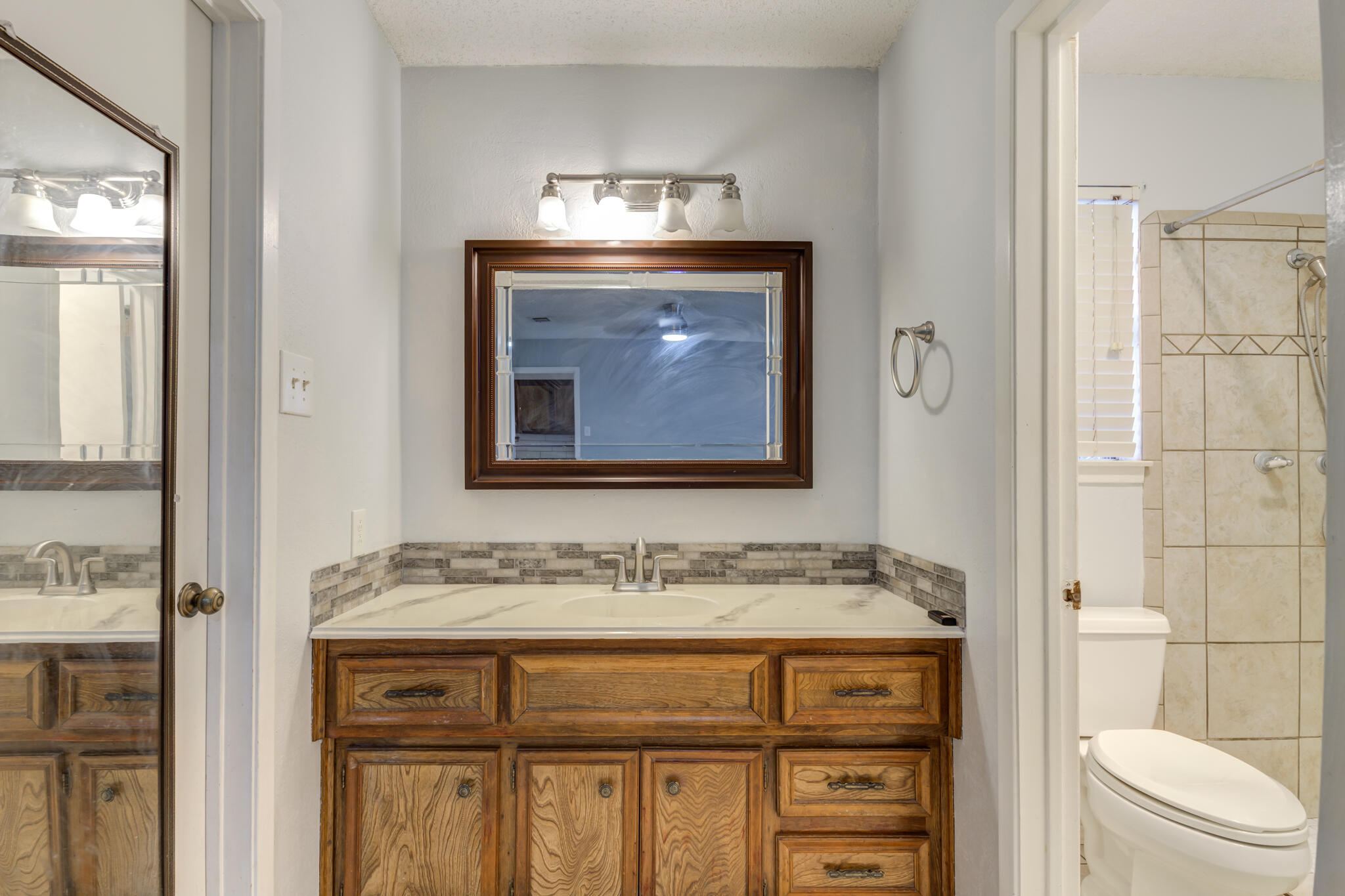 5018 70th Street Lubbock, TX 79424 - Photo 17 of 27 a bathroom with a granite countertop sink toilet and shower