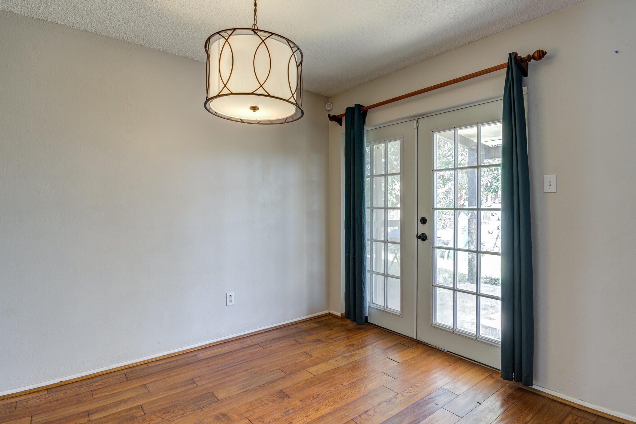 5018 70th Street Lubbock, TX 79424 - Photo 10 of 27 a view of an empty room with wooden floor and a window