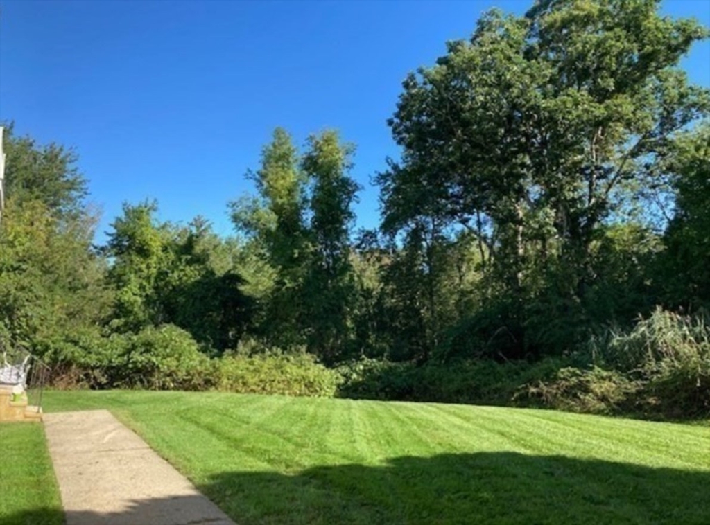 1475 Braley Road, Unit 17 New Bedford, MA 02745 - Photo 13 of 13 a view of a grassy field with trees in the background