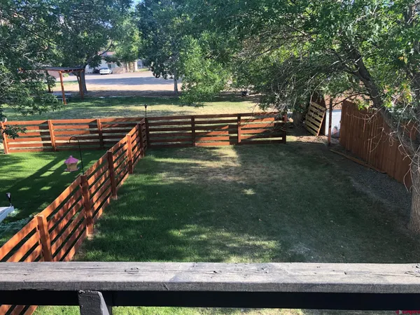 a view of a patio with table and chairs with wooden fence and plants