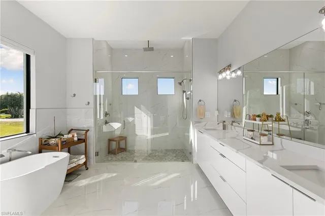 a spacious bathroom with a double vanity sink a large mirror and a bathtub