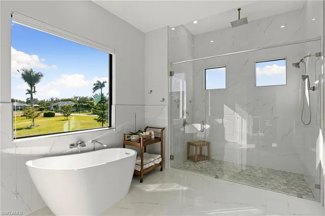 a bathroom with a large tub a shower and view