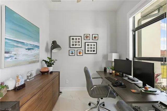 a view of a workspace with furniture and a window