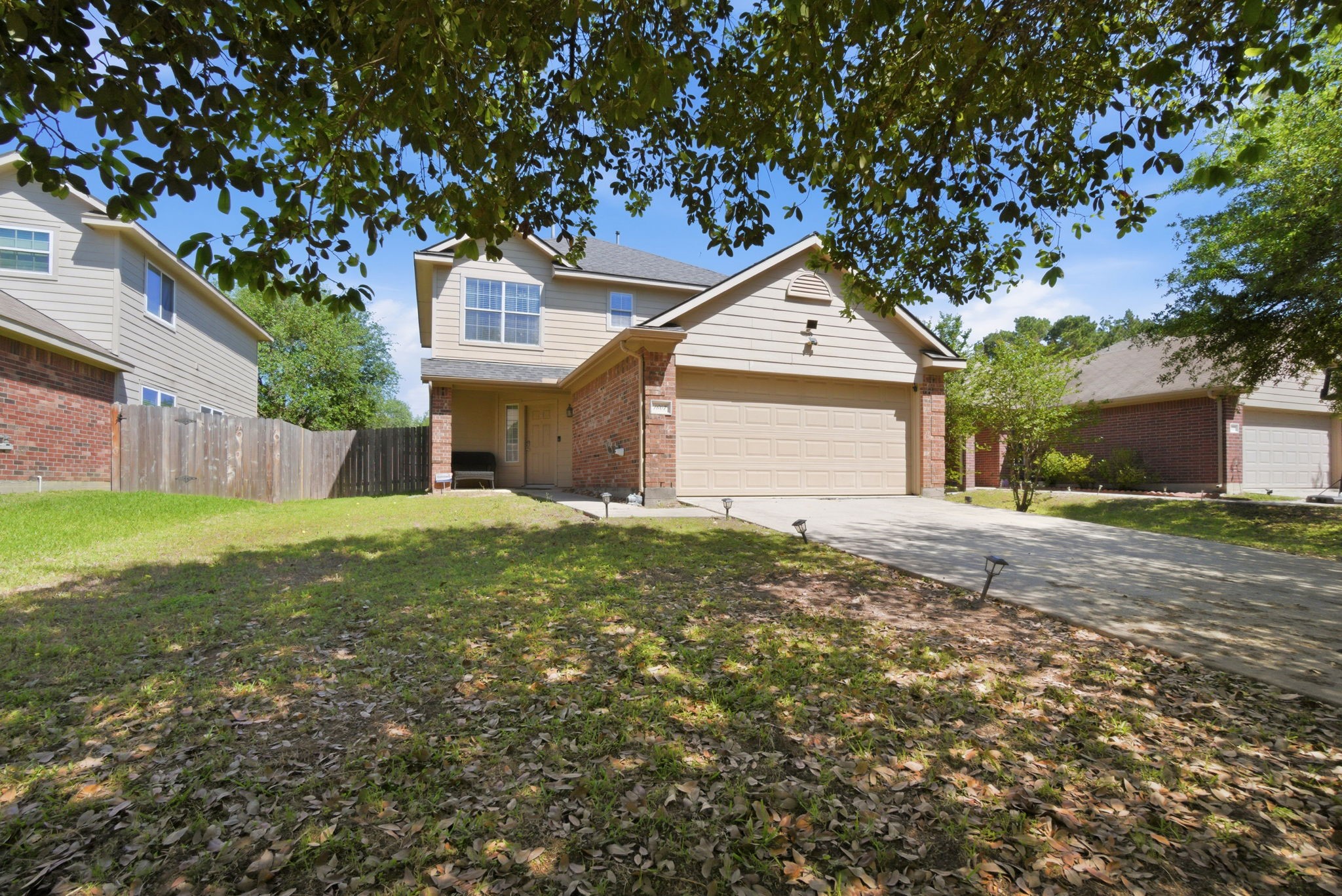 1607 Redbud Grove Court Conroe, TX 77301 - Photo 2 of 21 a backyard of a house with plants and large tree