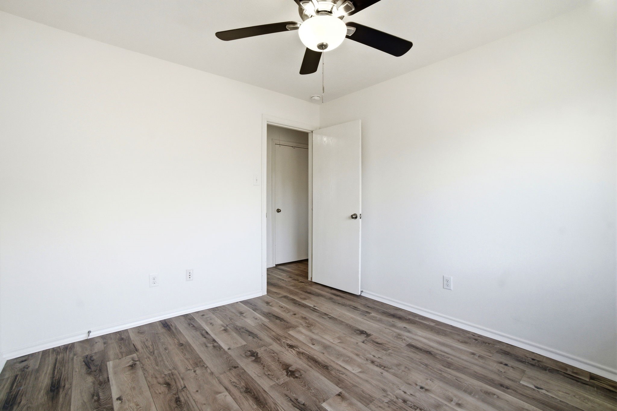 1607 Redbud Grove Court Conroe, TX 77301 - Photo 10 of 21 an empty room with wooden floor ceiling fan and window