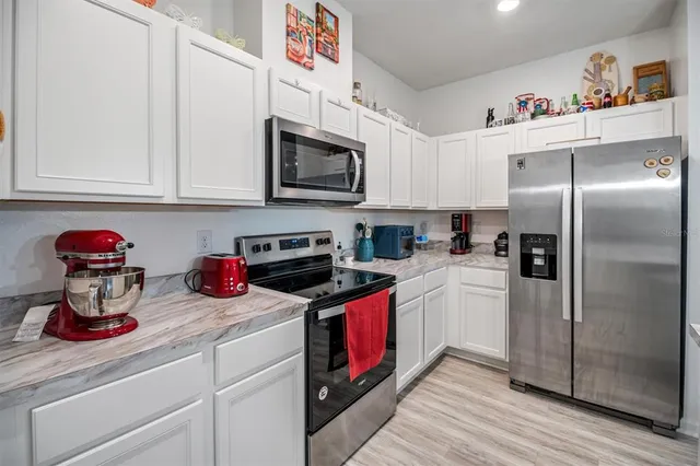a kitchen with stainless steel appliances granite countertop a sink and a refrigerator