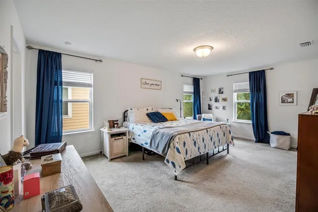 a spacious bedroom with a bed and a window