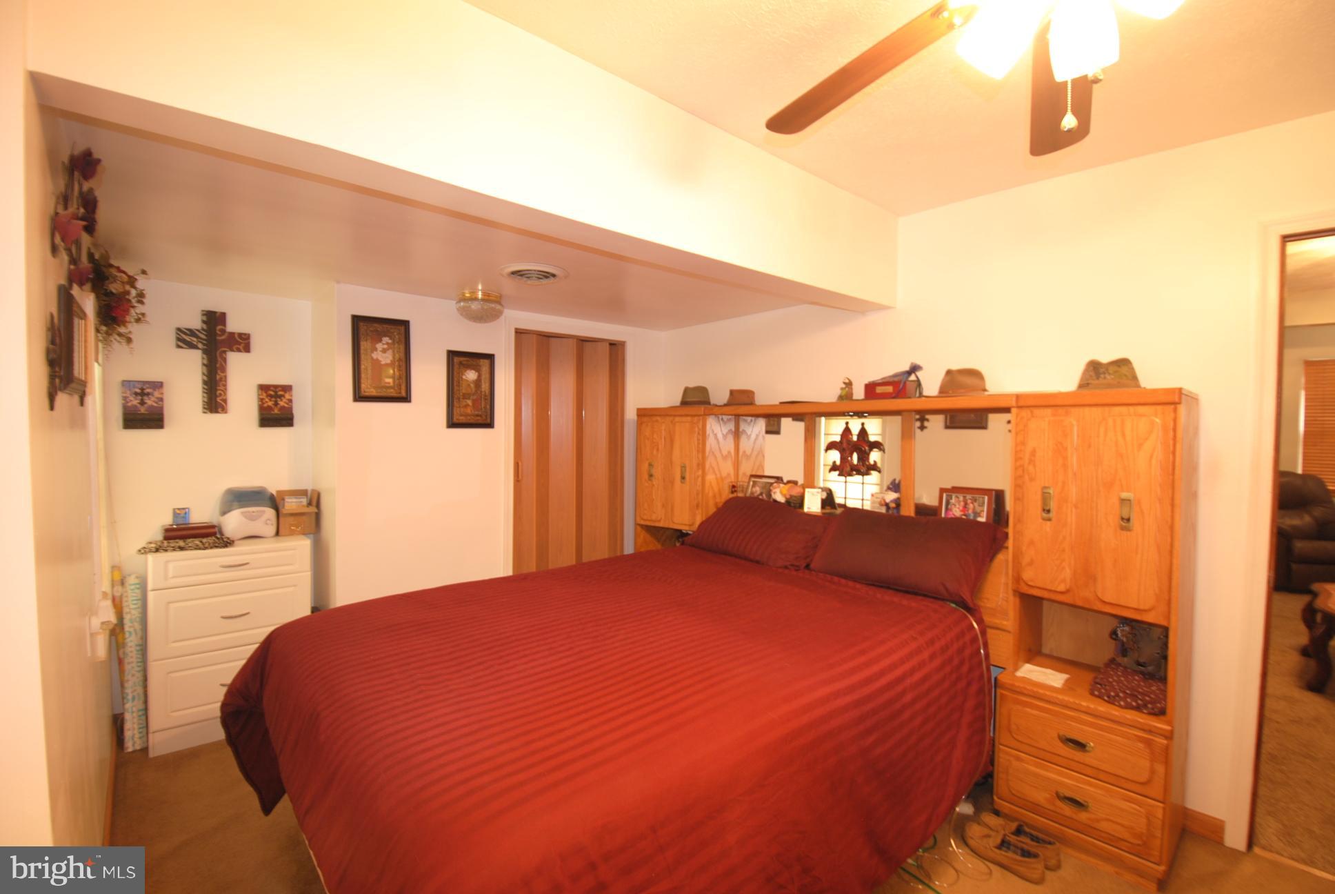 345 Sinking Spring Lane Gore, VA 22637 - Photo 14 of 30 a bed sitting in a bedroom next to a window with a kitchen
