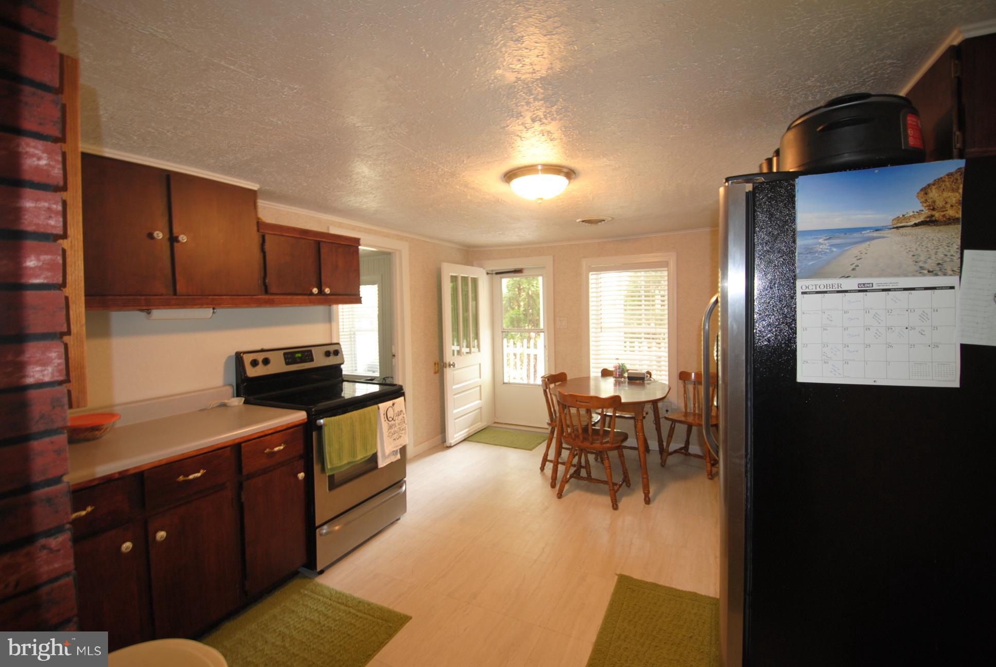 345 Sinking Spring Lane Gore, VA 22637 - Photo 5 of 30 a kitchen with stainless steel appliances granite countertop a stove top oven a sink a dining table and chairs with wooden floor
