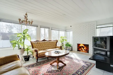 a living room with furniture a fireplace and a chandelier