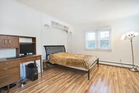 a bedroom with a bed and a flat tv screen on dresser