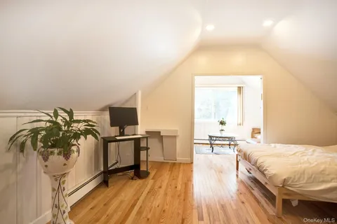 a spacious bedroom with a bed and flat screen tv