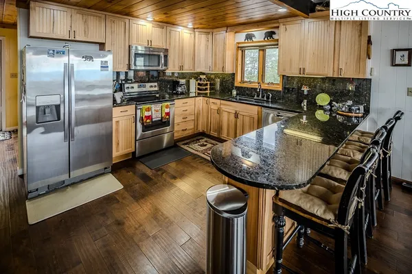 a kitchen with stainless steel appliances granite countertop a sink a stove and a refrigerator